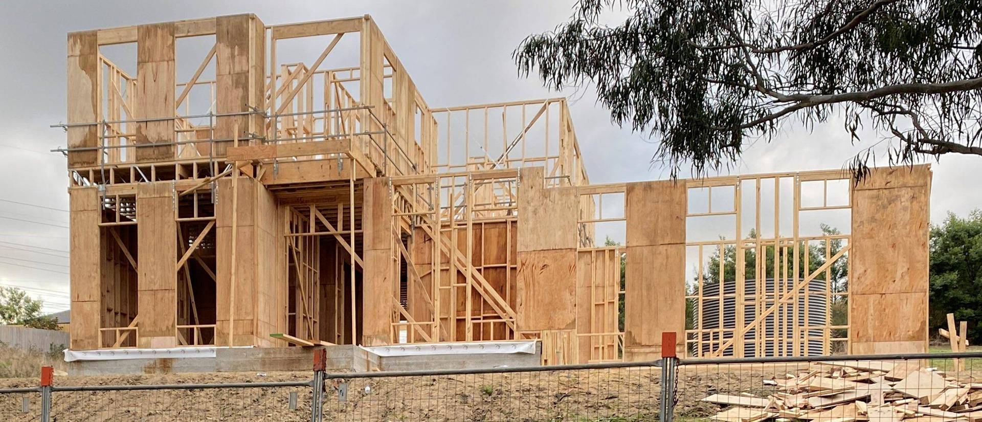 newly built wooden frame of a house with safety scaffolding