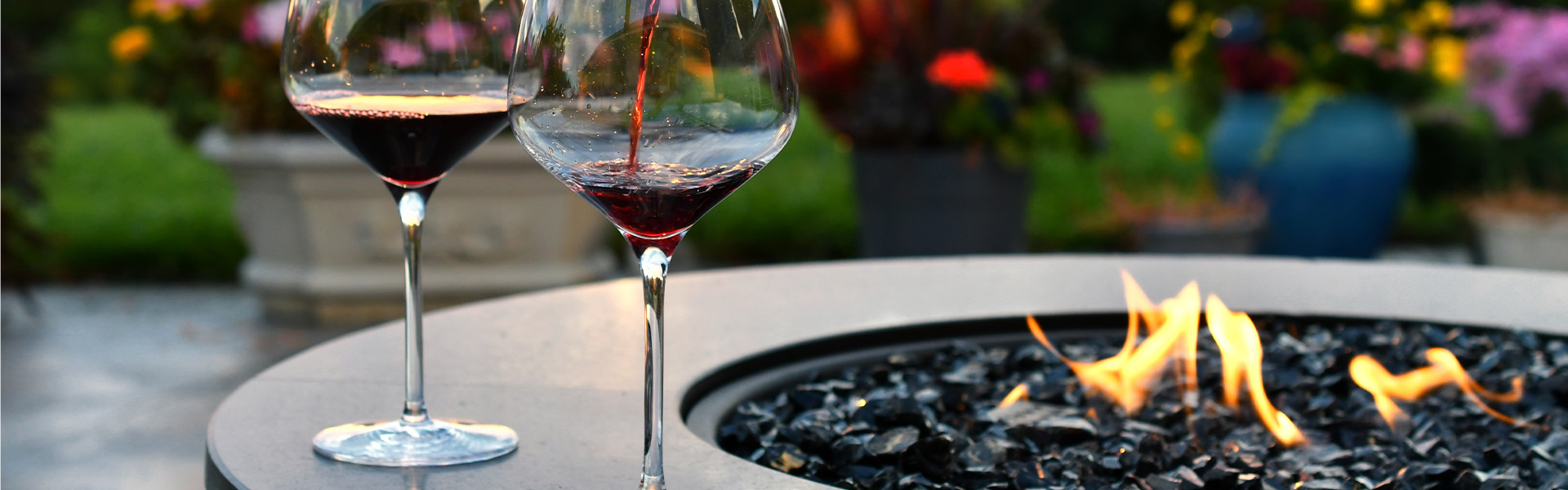 Outdoor firepit with wine glasses on the rim