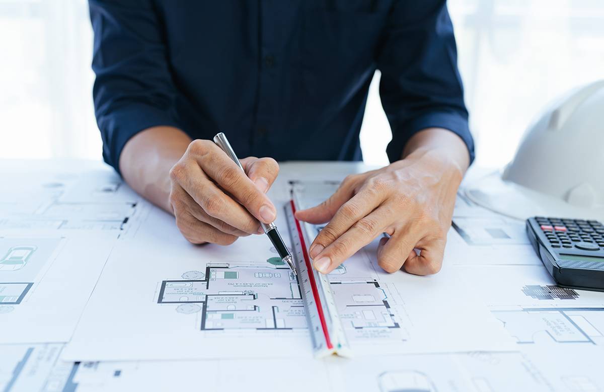 Person measuring against building layout