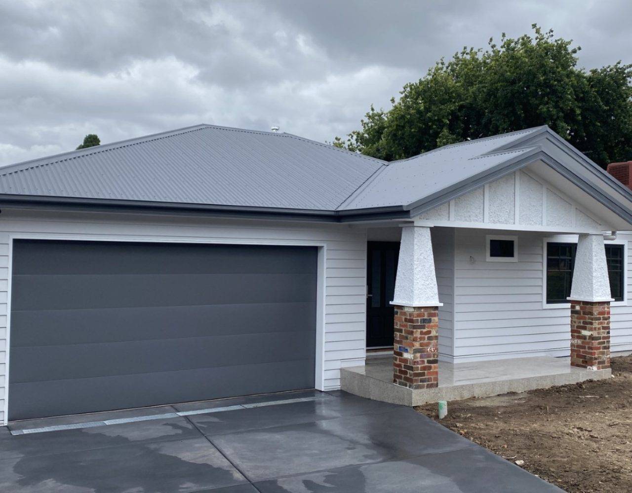 White weatherboard house with metal roof.