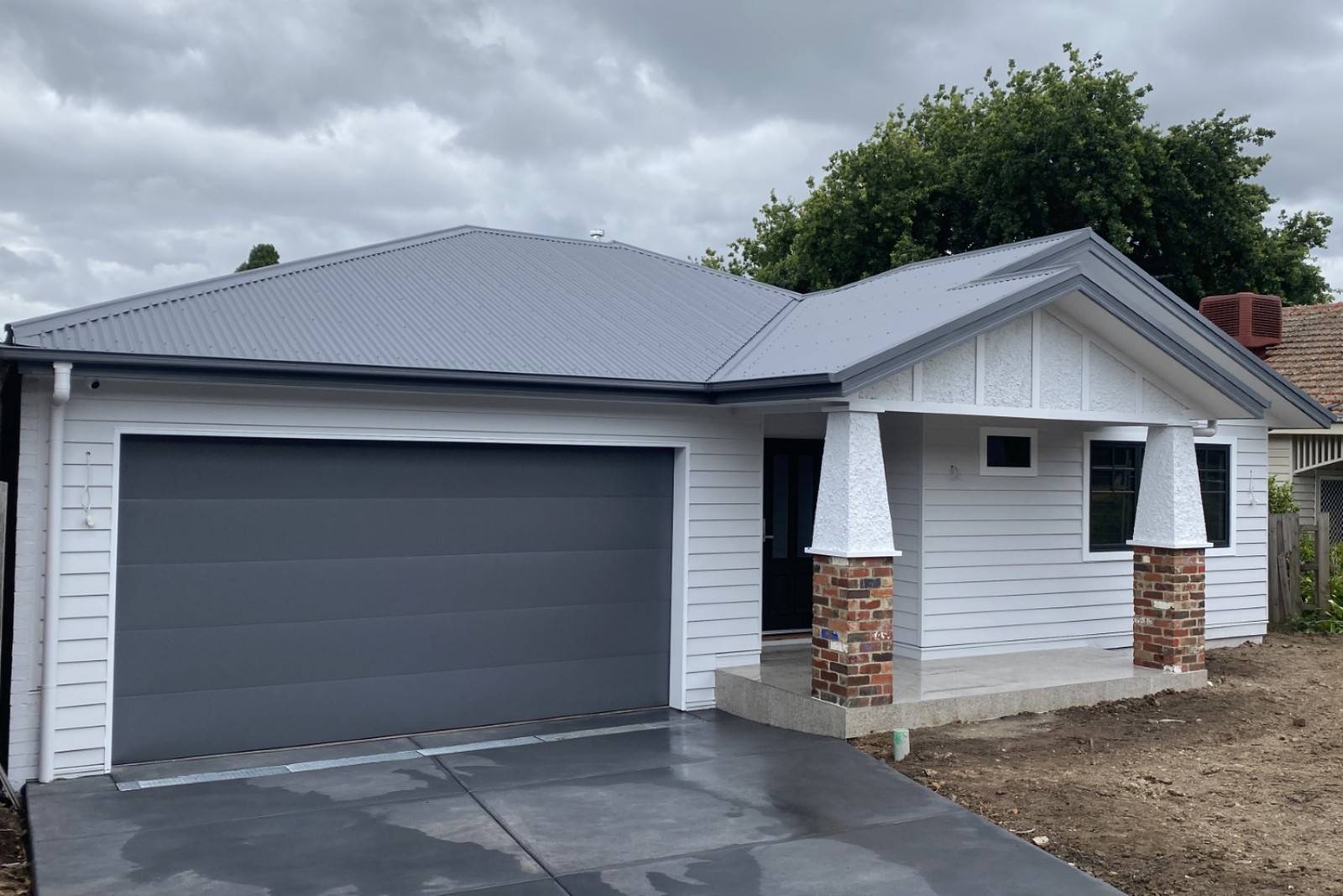 White weatherboard house with metal roof.