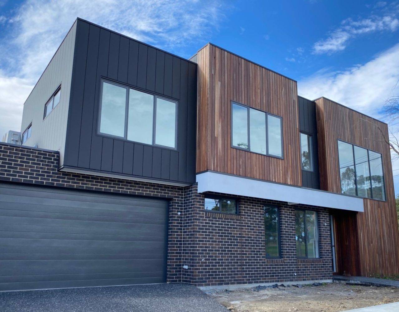 Modern cubic house with different types of wooden walls and brick walls.