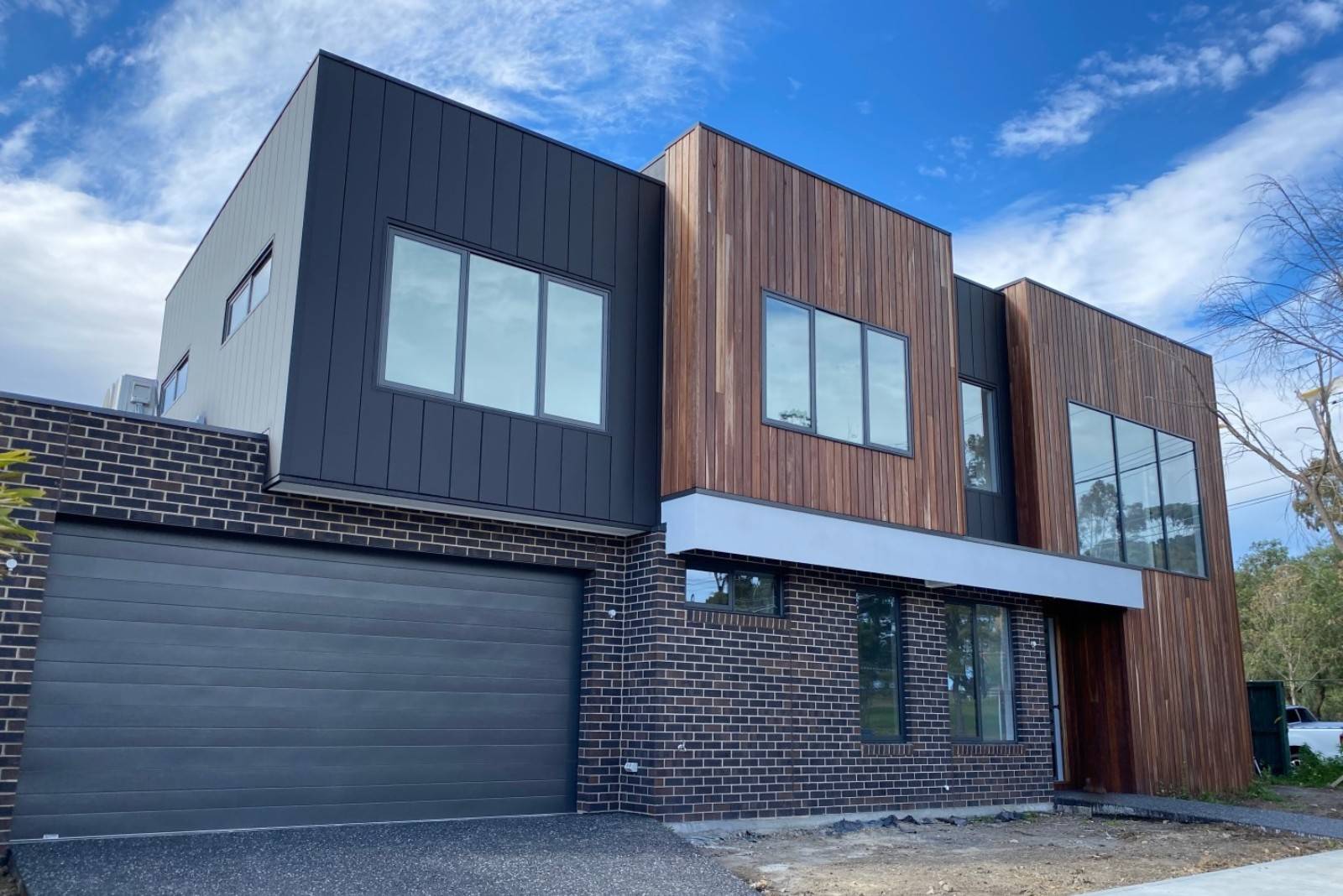 Modern cubic house with different types of wooden walls and brick walls.