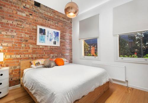 Master bedroom with a brick wall